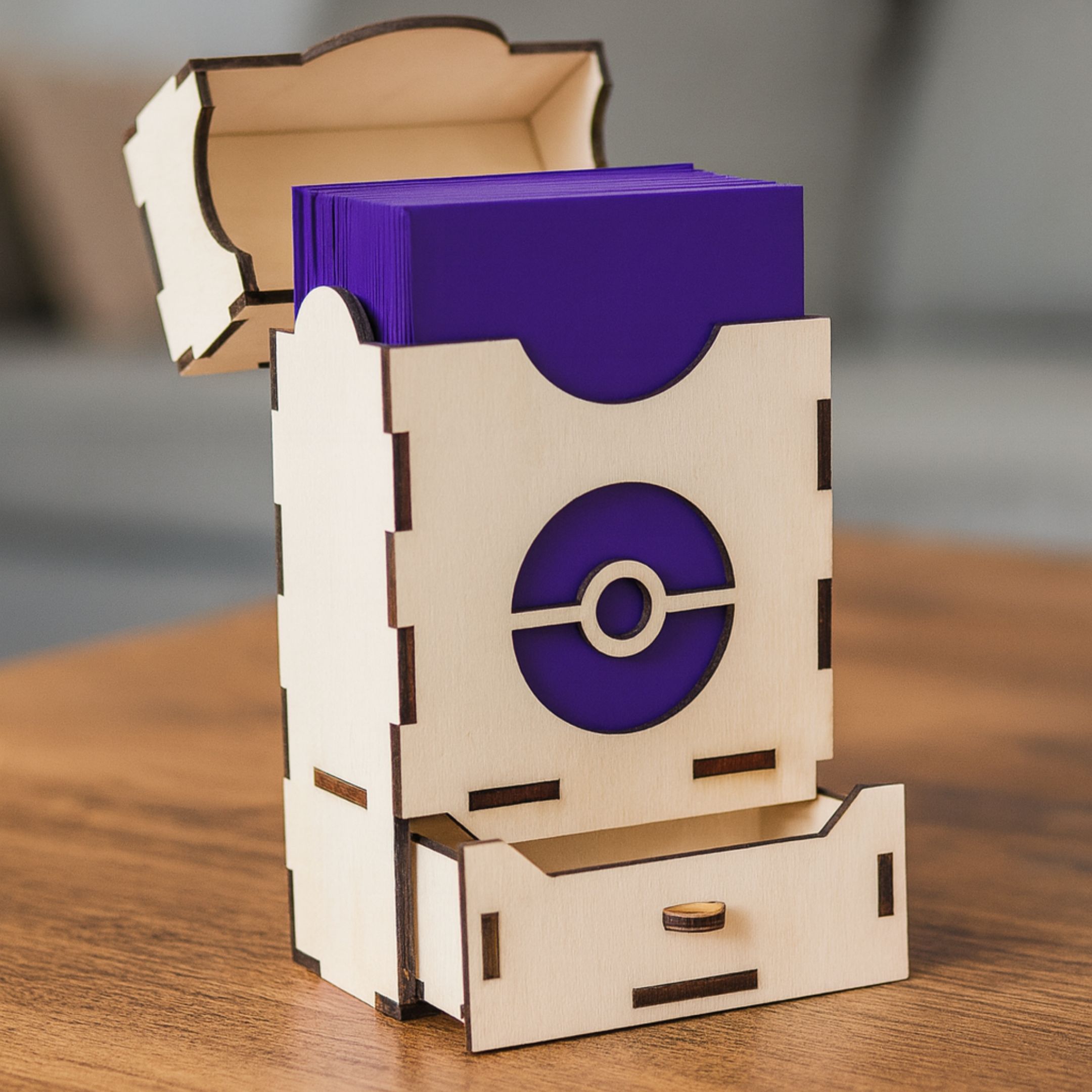 Laser cut wooden deck box with Pokéball-inspired design on a table in a cozy room.
