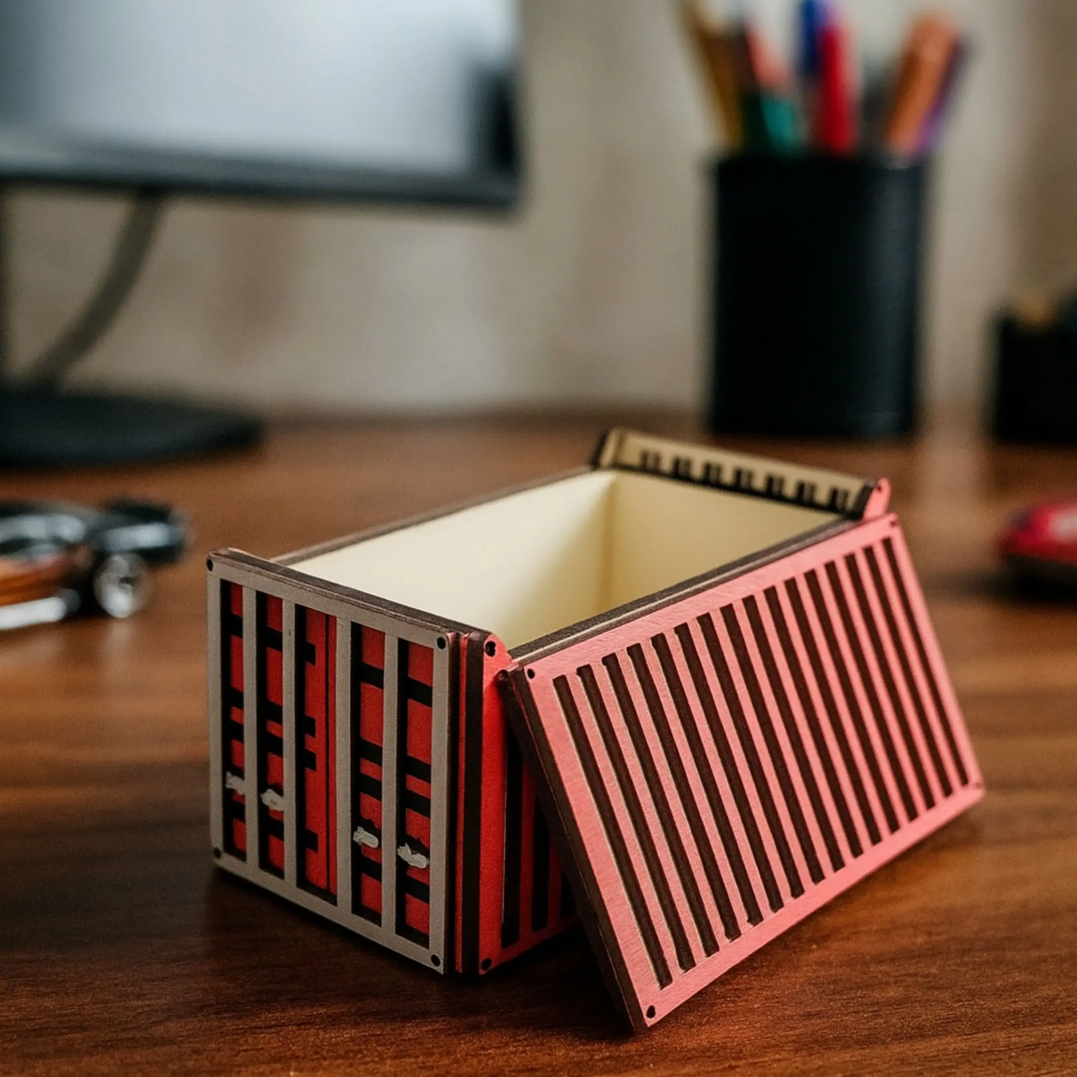 Laser cut Hot Wheels container on a table with toy cars in the background