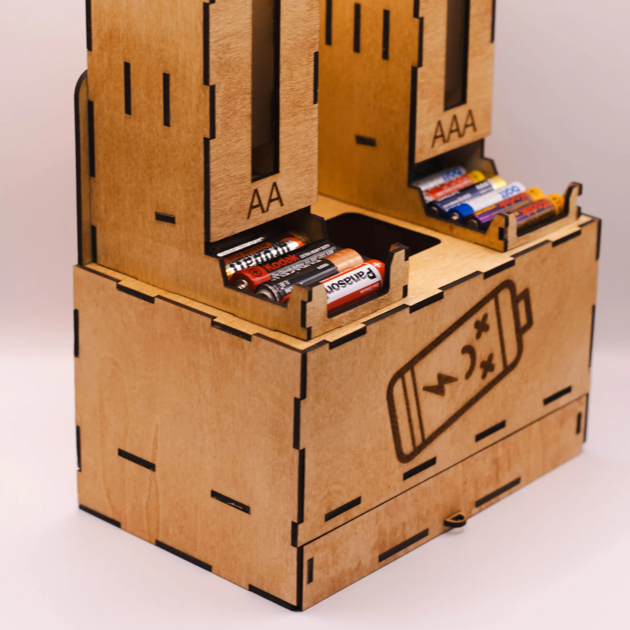 Side view of the opposite edge of a laser cut wooden battery organizer for AA, AAA, and flat batteries