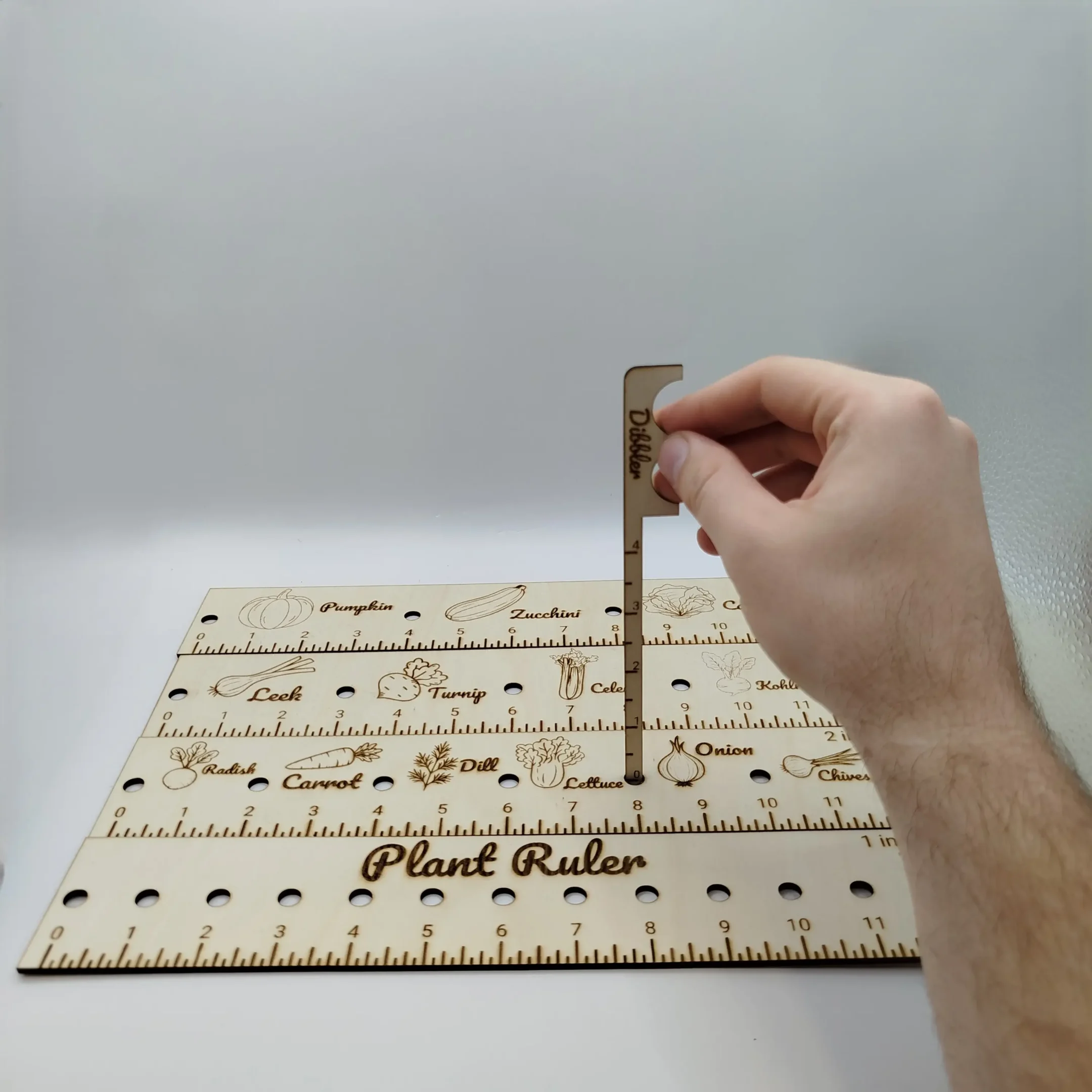 Laser cut garden dibbler shown with depth markings, displayed on a white background