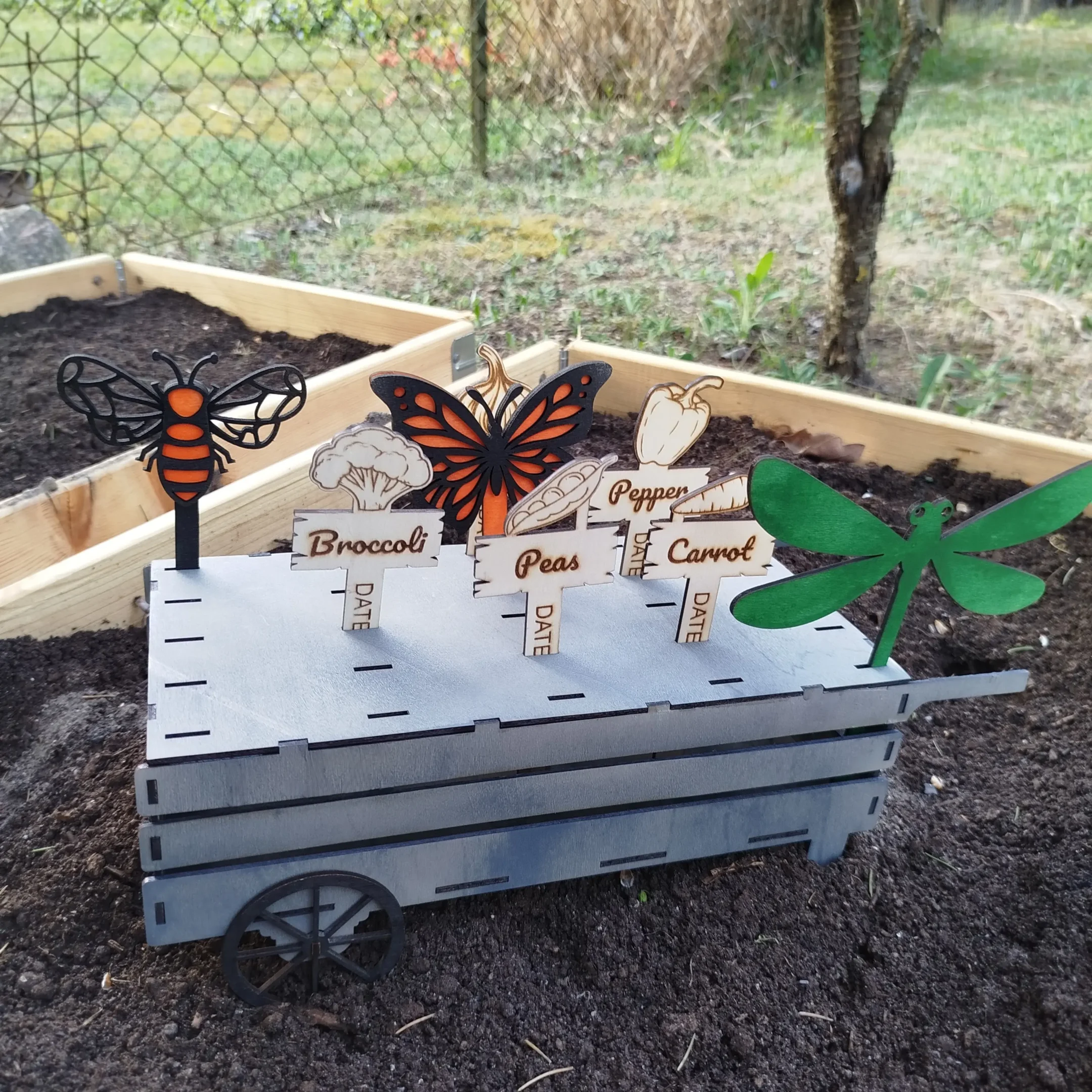 Wooden laser cut cart filled with plant markers for garden labeling, organized and ready to use