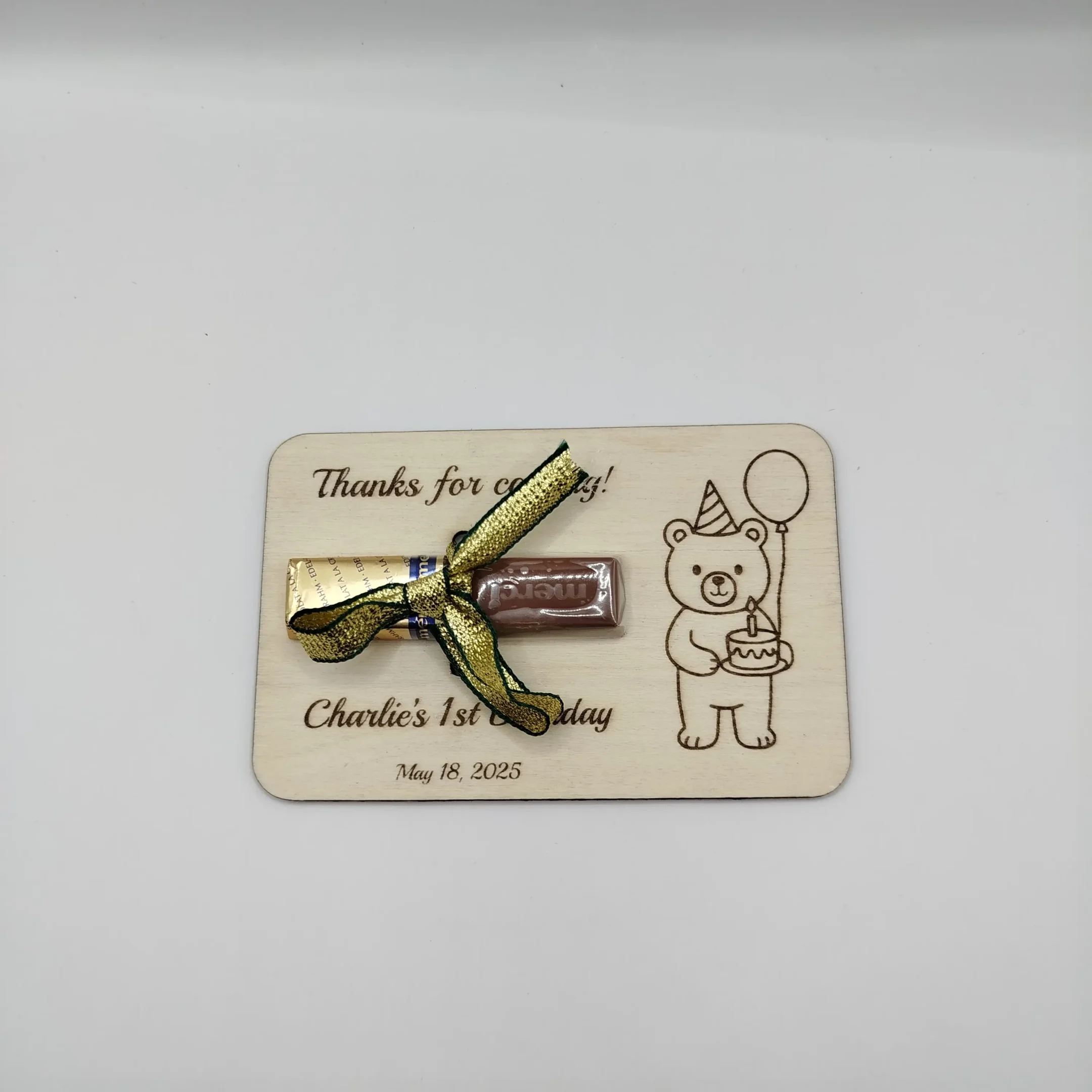 Laser cut wooden bear party favor with Merci chocolate inserted, personalized for a special occasion