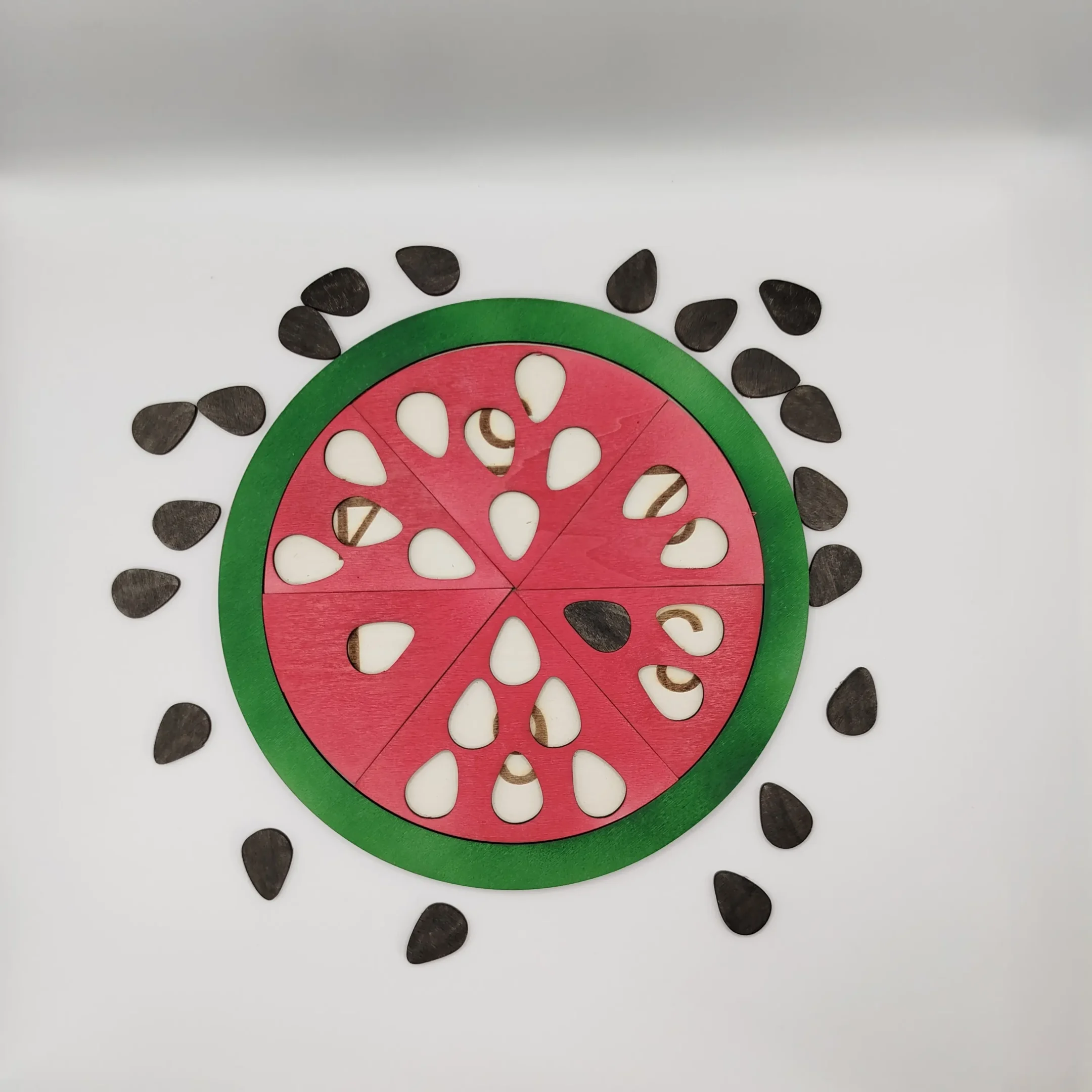 Wooden watermelon puzzle with all slices inserted, shown without the removable seeds.
