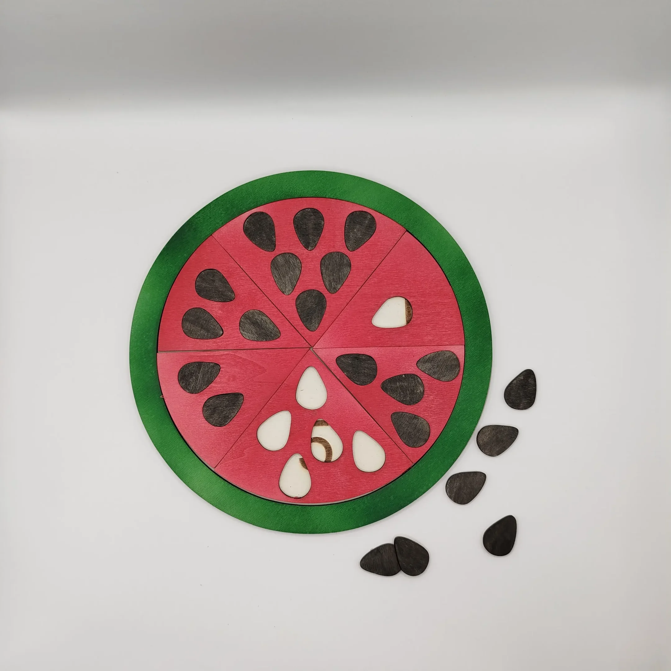Completed wooden watermelon puzzle with all numbered slices inserted into the board.