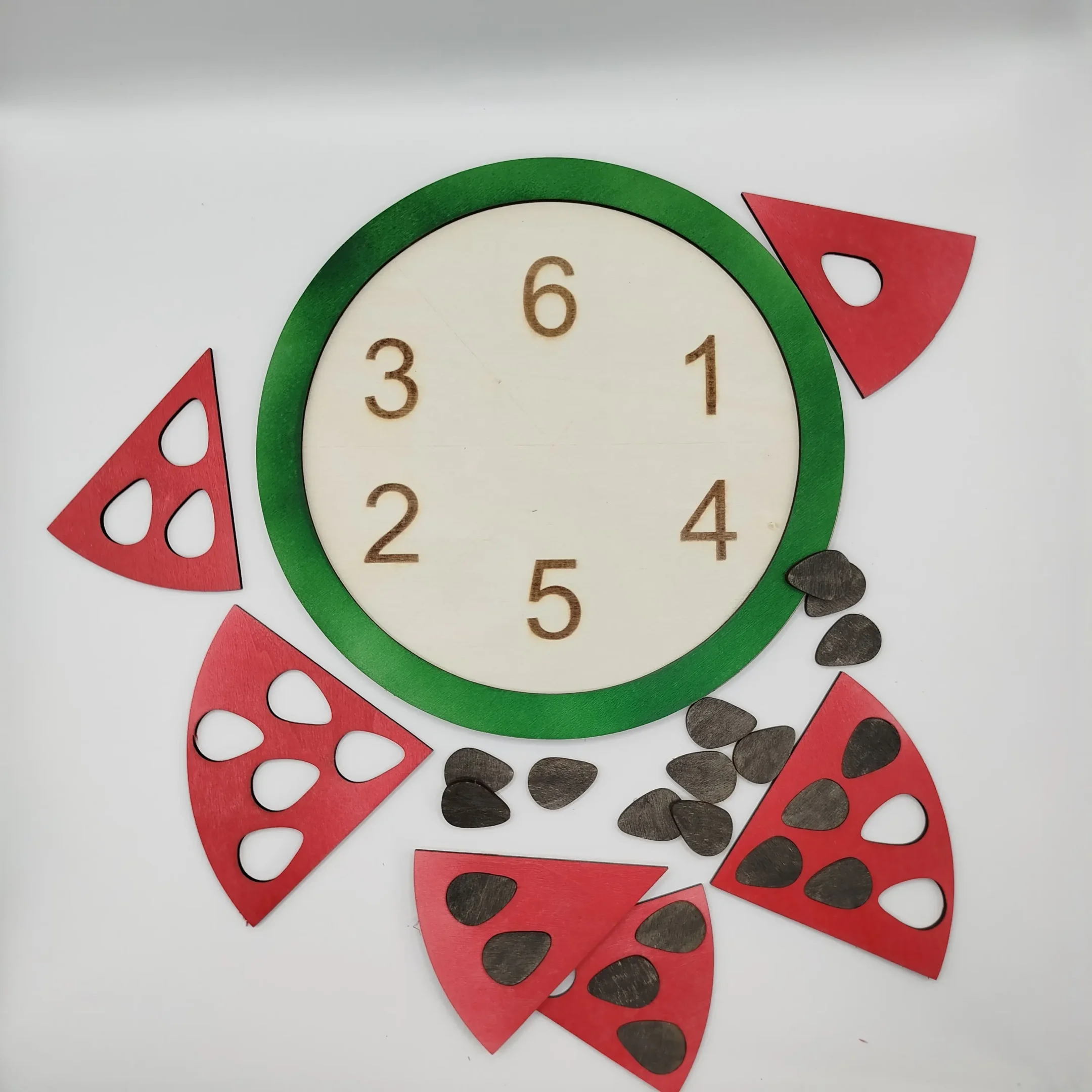 Disassembled wooden watermelon puzzle with numbered slices and seeds placed around the empty board.