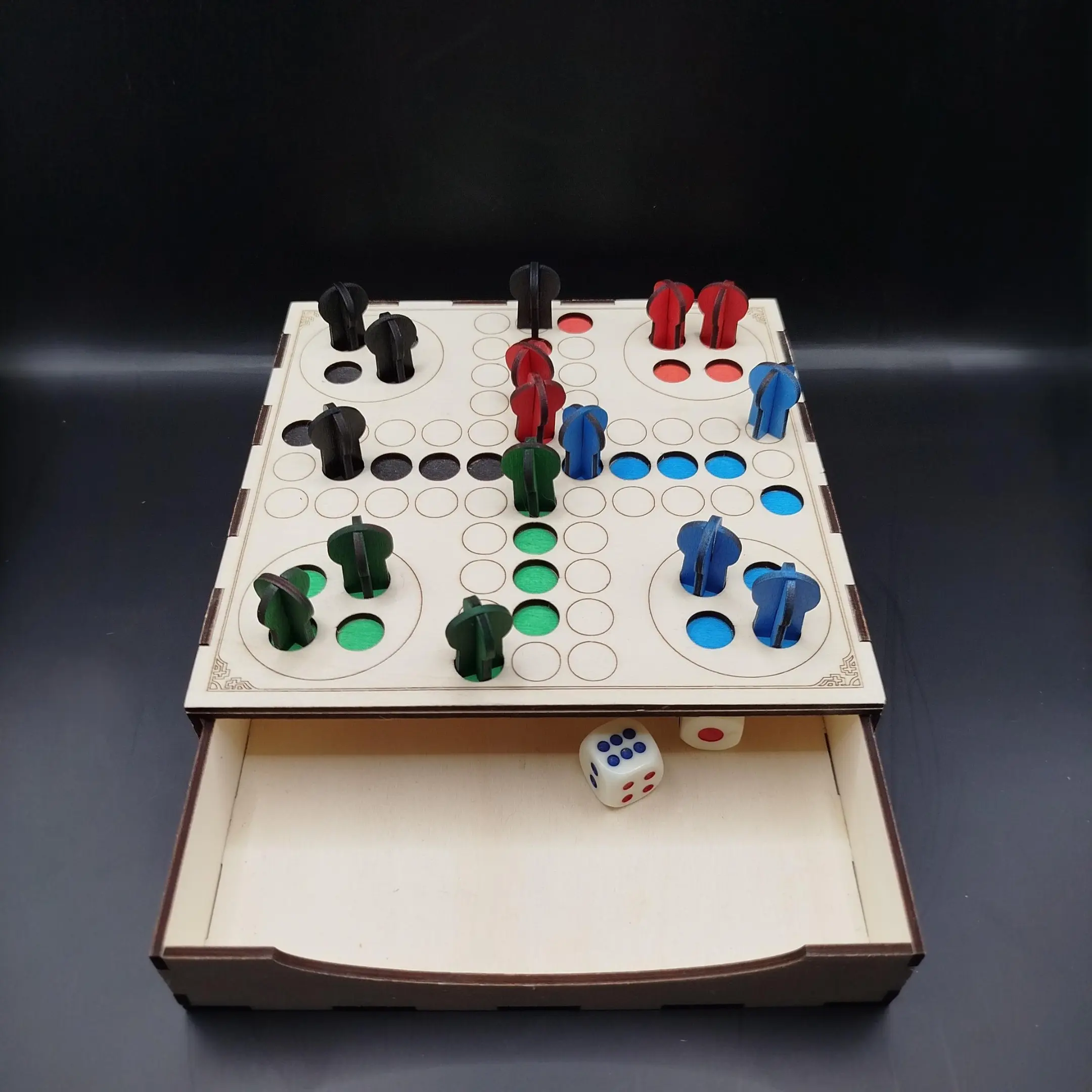Laser cut wooden Ludo board game with colorful peg holes.