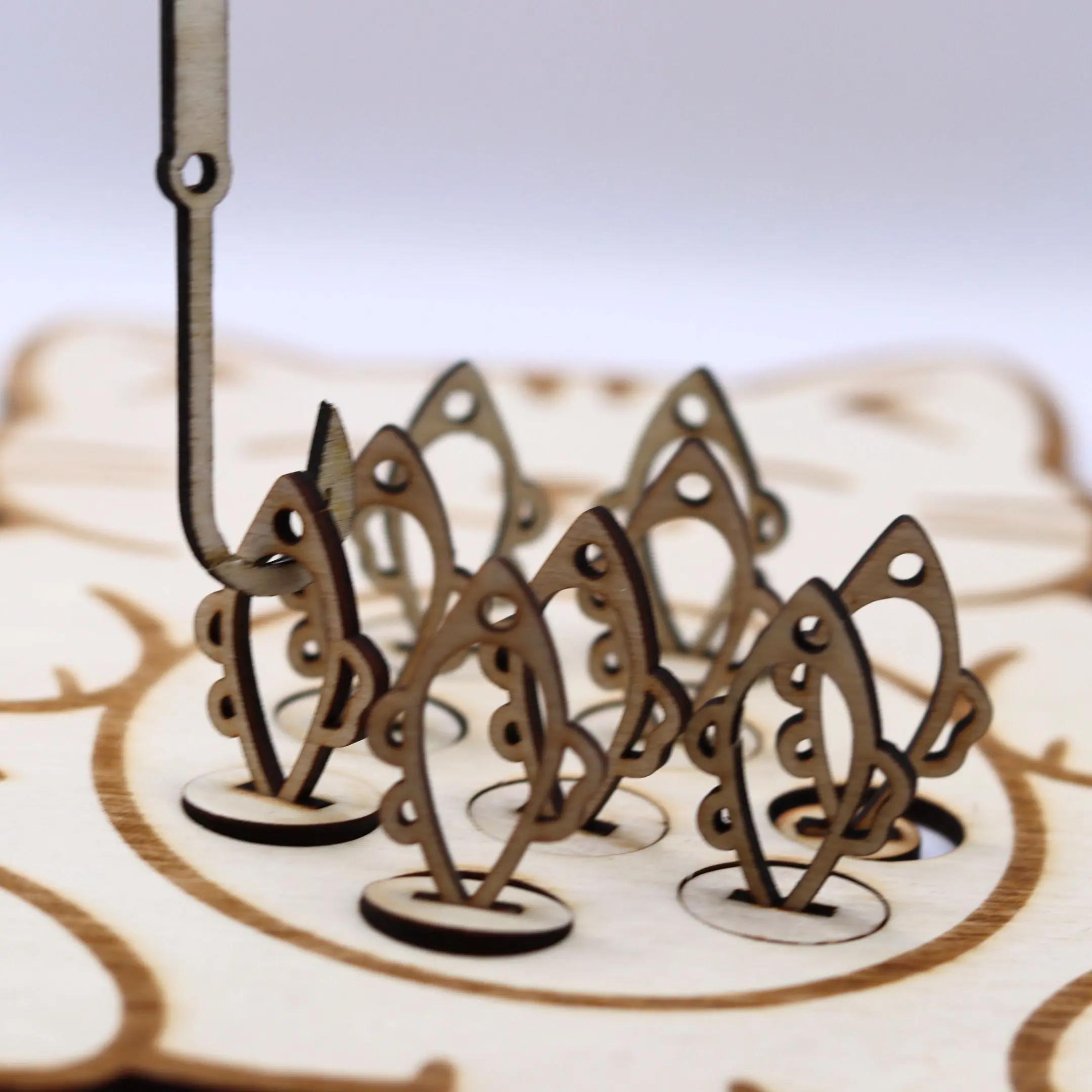 Wooden fishing rod catching a fish piece from the cat-shaped game board.